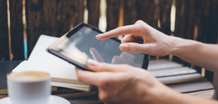 Young woman using digital tablet on summer terraceの写真素材