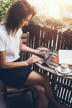 Young woman using digital tablet on summer terraceの写真素材