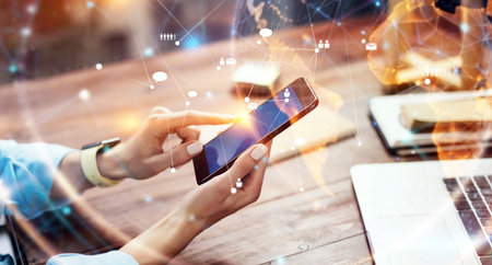 Close-up photo of female hands with smartphone. Concept of networking or remote work. Global business network. Social connectionsの写真素材
