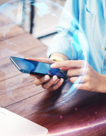Close-up photo of female hands with smartphone. Concept of networking or remote work. Global business network. Social connectionsの写真素材