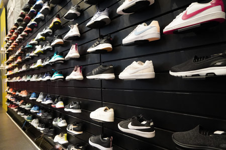 Shop display of a lot of Sports shoes on a wall. A view of a wall of shoes inside the store. Modern...