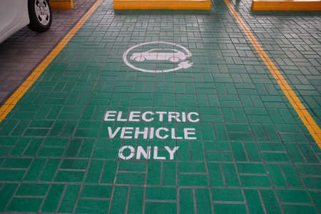 Green electric vehicle charging station sign in a parking bay. Electric vehicle parking space. Electric car charging station. Dubai UAE December 2019のeditorial素材