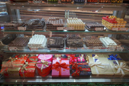 Close up of several chocolate sweets in a shop. Chocolate candy in a store window. Stand with chocolates. Collection of delicious chocolate candies with different fillings. - Dubai UAE December 2019のeditorial素材