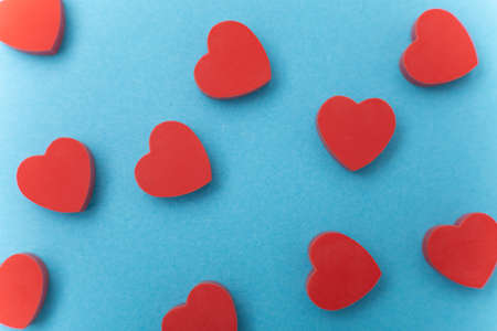 Small red hearts on a blue background. Background love symbol. Flat layの写真素材