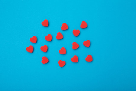 Small red hearts on a blue background. Background love symbol . Flat lay.Copy space