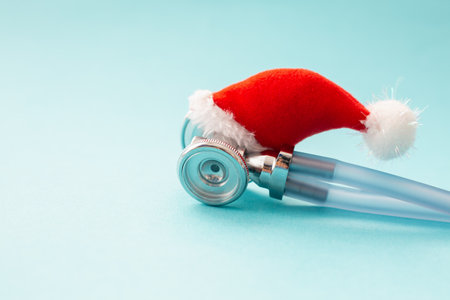 Medical stethoscope in a red Santa Claus hat, blue background. Christmas and new year concept. Creative medical winter background, postcard.Close upの写真素材