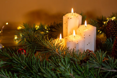 Christmas and New Year candles and ornaments over dark background with lights. Advent - Four purple...