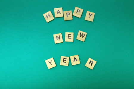 Wooden letters laid out Happy New Year on a turquoise background. Happy New Year 2024. Flat lay....