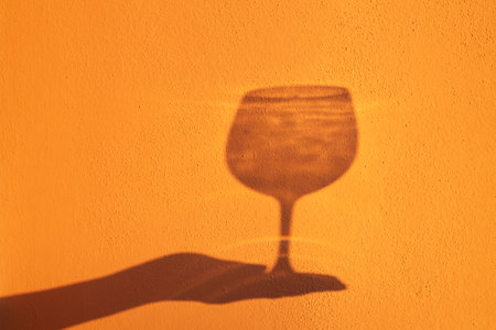 Elegance of glasses and goblets in the hands of a woman on a yellow background.の写真素材