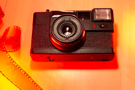 Old 35mm film camera, vintage analog in classic retro style, with 3 5mm negative photographic film strip.Retro camera.の写真素材