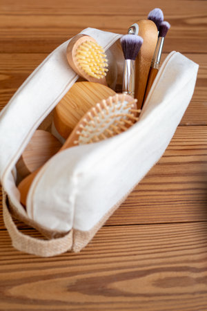 A wooden comb, a wooden roller for restorative facial massage, lymphatic drainage, and wrinkle reduction, and bamboo makeup brushes in a natural linen bag onの写真素材