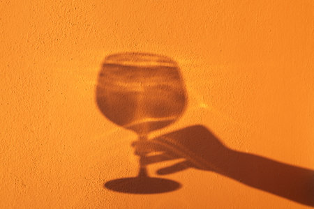 Elegance of glasses and goblets in the hands of a woman on a yellow background.の写真素材