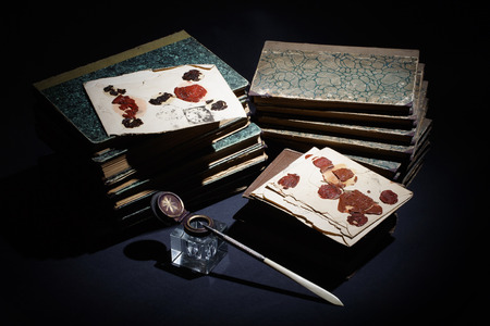 old books, papers, ink pen and inkpot on blackの写真素材