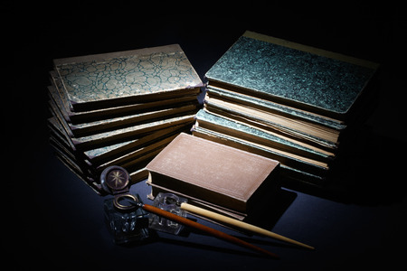 old books, papers, ink pen and inkpot on black backgroundの写真素材