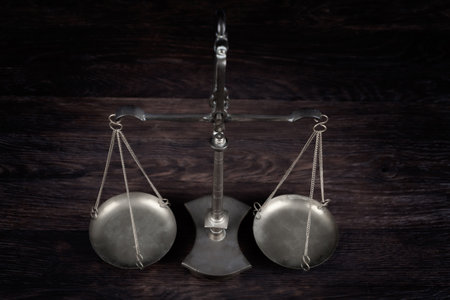 Bronze traditional balance scale on wooden table background.の写真素材
