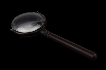 Antique magnifying glass with reflection on black backgroundの写真素材