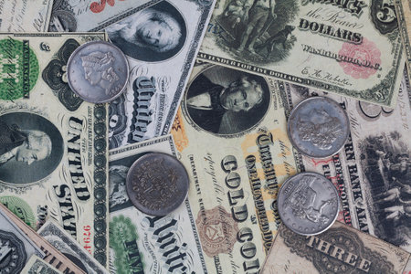 Old west US banknotes and silver certificates with silver dollar coins backgroundの写真素材