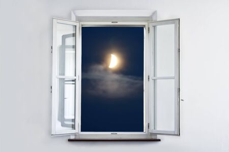 The moon at night, looking out open white window.の写真素材