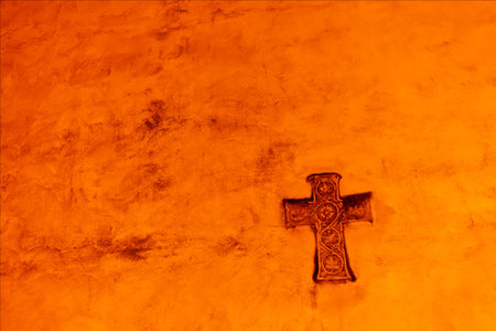 Bas-relief, medieval wall sculpture in the village of Strassoldo. Cross of jesus christ. Night photography.の写真素材