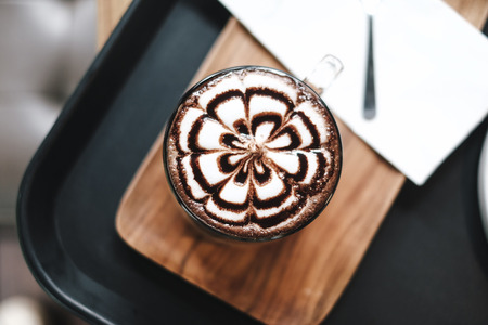 Art in chocolate drink on wood plateの写真素材