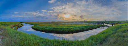 Panorama of salt marsh, mud flat and bridge over marsh channel in Sankt Peter Ording at the SÃ¼dstrand. Typical Waddensea landscape.の写真素材