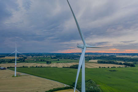 Aerial view of wind turbine with wheat and maize fields in summer. Aerial view of Eolian generator with agriculture fields in the countryside.の写真素材