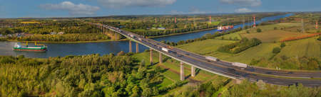 Cargo ships and motorway bridge. The Rader HochbrÃ¼cke crosses the A 7 federal motorway between the Rendsburg BÃ¼delsdorf junction and the Rendsburg interchange via Kiel Canal and "Borgstedter Enge".の写真素材