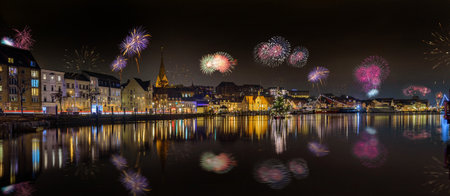 Panorama view of festive lighting. Fireworks and New Year romantic atmosphere in the Flensburg at night. Nighttime view of Flensburg FÃ¶rde at Silvester time. Maritime New Year's Eve city.のeditorial素材