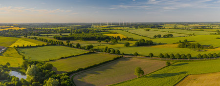 Aerial view of green fields and windmills in the countryside.