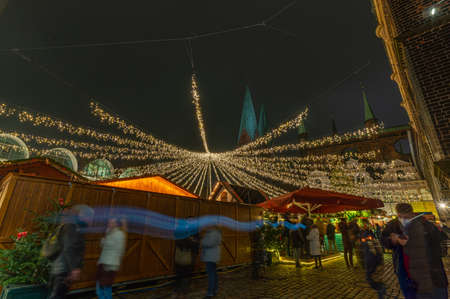 Christmas market in Germany. Christmas atmosphere of the city at evening. Christmas market in the historic center of the city. Christmas Fair at night, Lubeck, Germany, Europeの写真素材