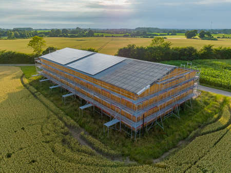 Solar panels on farm barn. Agriculture barn under renovation works with construction scaffolding frame. Recently renovated barn with photovoltaic module on the rooftop. solar paneの写真素材