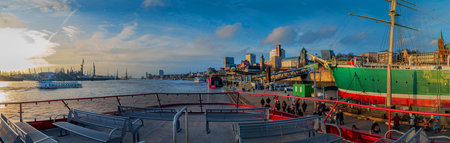 View over board of passenger ferry over Elbe, landing pier LandungsbrÃ¼cken, the skyline of St. Pauli and Hamburg port.のeditorial素材