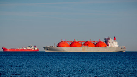 LNG (Liquified Natural Gas) tanker and tanker anchored and waited near port. LNG Tanker and small tanker awaiting port access.の写真素材