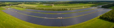 Aerial view of solar power plant with solar panels on green fieldの写真素材