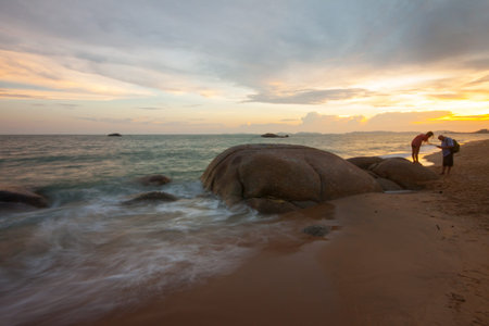 peoples in view of a rocky coast in sunset