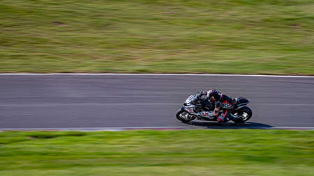 A panning shot of a racing bike cornering on a track.の写真素材