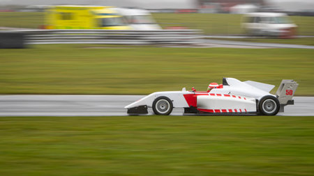 A panning shot of a racing car as it circuits a track.のeditorial素材
