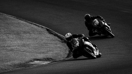 A monochrome shot of a racing motorbike as it circuits a track.の写真素材