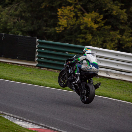 A panning shot of a racing motorbike as it circuits a track.