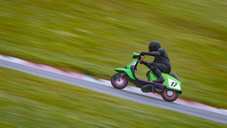 A panning shot of a racing moped as it circuits a track.の写真素材