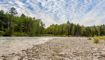 Sunset over the upper Kitimat River in Northern British Columbia, Canada, with a cloudy blue sky,...