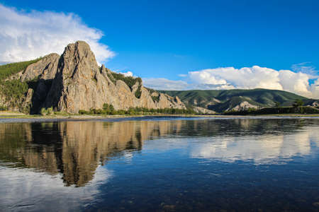 A mountain reflecting off the Delger Murun river, in the evening sun in Mongolia.の写真素材