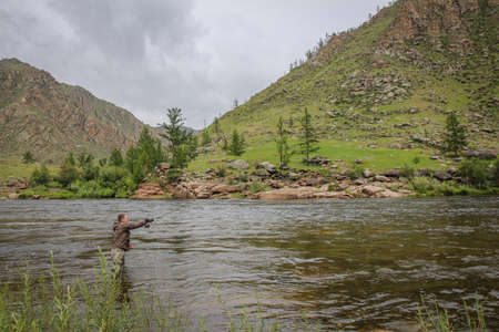 Fly fisherman casting a fly on the Delger Moron river in Mongolia during the summer, Moron, Mongoliaの写真素材