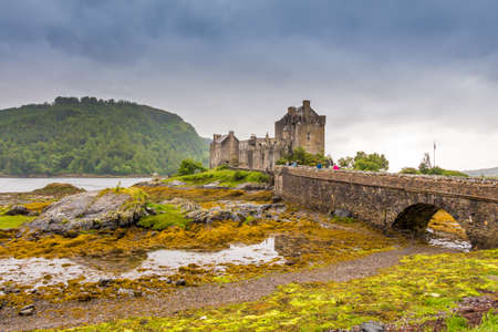 Stormy evening clouds over Eilean Donan Castle in the highlands of Scotland, at low tide.のeditorial素材