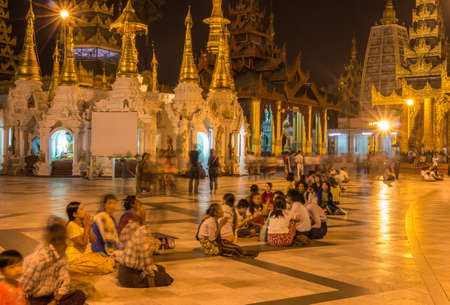 Yangon, Myanmar - December 18th 2017: Long exposure of Burmese people praying at the Shewdagon Pagoda in Yangon, Myanmarのeditorial素材