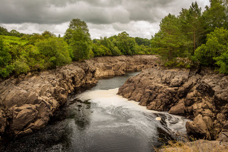 Water of Ken river flowing through a rocky gorge in Galloway, Scotland, due to Earlstoun Dam and...