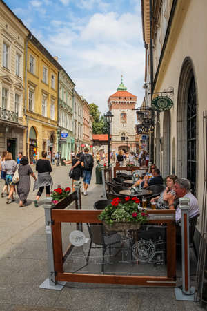 Krakow, Poland - July 29th 2018: Tourists sitting at a cafe on Florianska Street at St. Florian's Gate, in the old town of Krakow, Poland.のeditorial素材