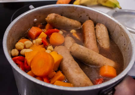 Sausage casserole stew in a pot with carrots, chickpea, red pepper and gravyの写真素材