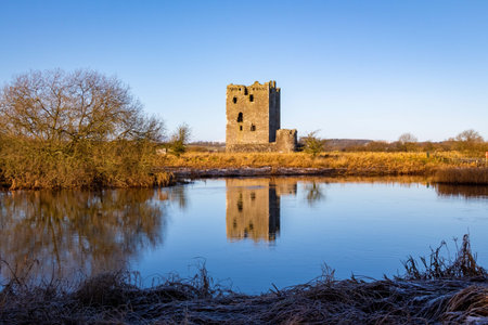 Threave Castle reflecting on the River Dee in the winter sun, with frost on the ground, Dumfries and Galloway, Scotlandの写真素材