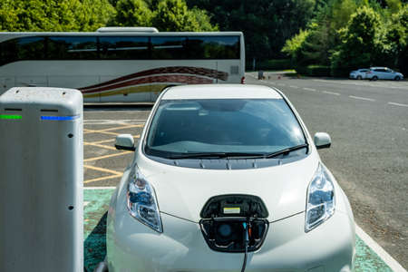 An electric vehicle charging while being parked at a car park in Scotlandの写真素材